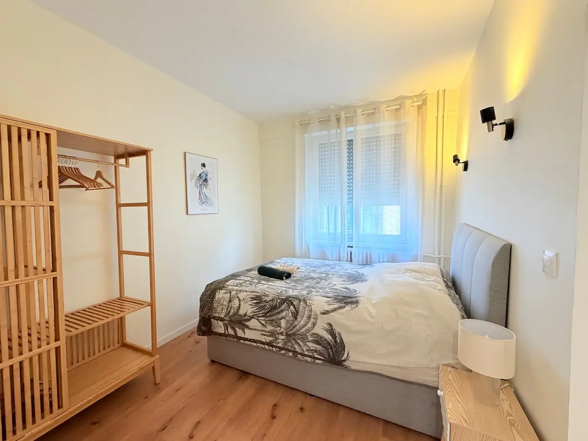 Chambre claire avec parquet et étagère en bois, Le Fuji à Mulhouse