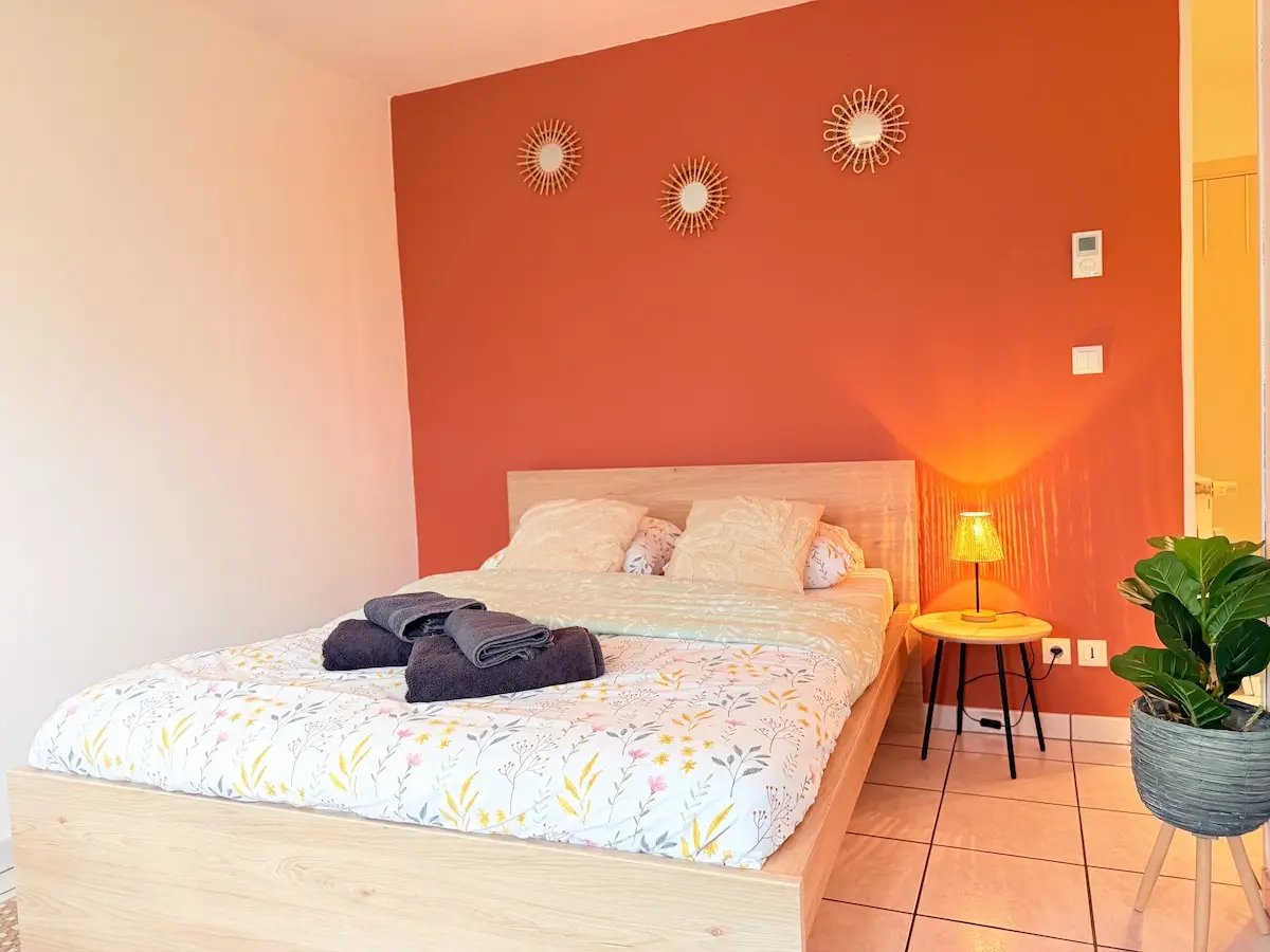 Chambre au mur terracotta éclairée d’une lampe d’appoint, Nid Douillet à Haguenau