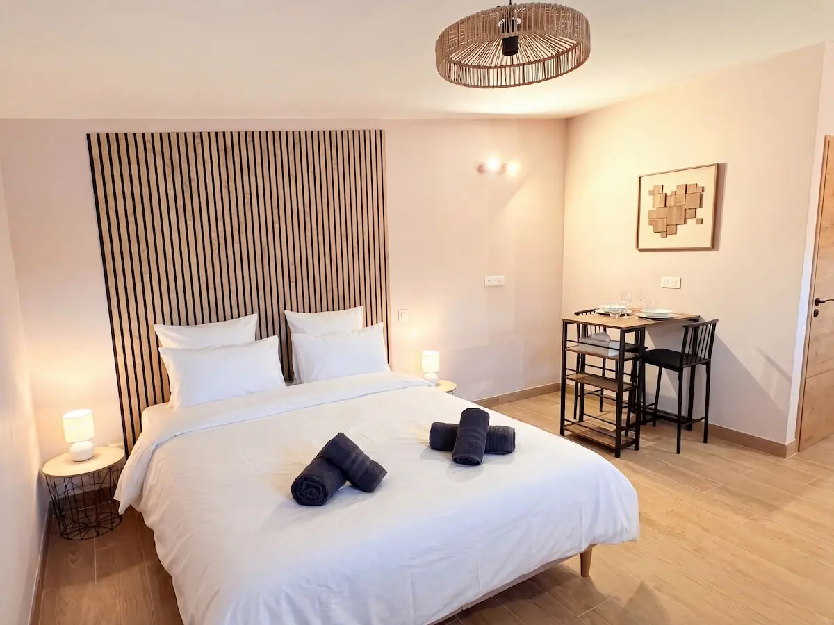 Chambre au mur de lattes de bois et appliques chaudes, Le Studio du Prêtor à Haguenau